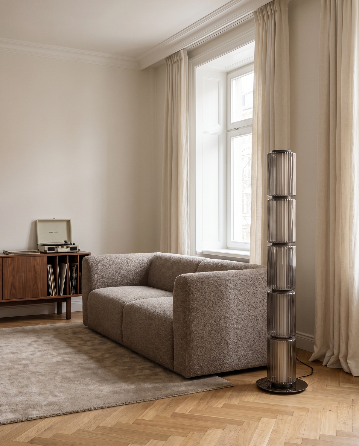 Barbican ribbed glass floor lamp in smoky grey beside a sofa in a London living room