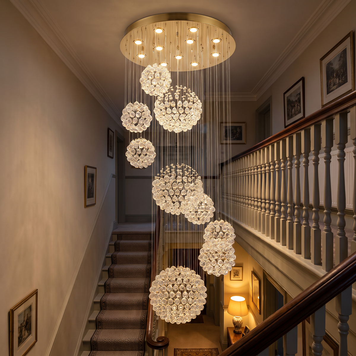 Henley raindrop chandelier lit in the evening above a Victorian staircase