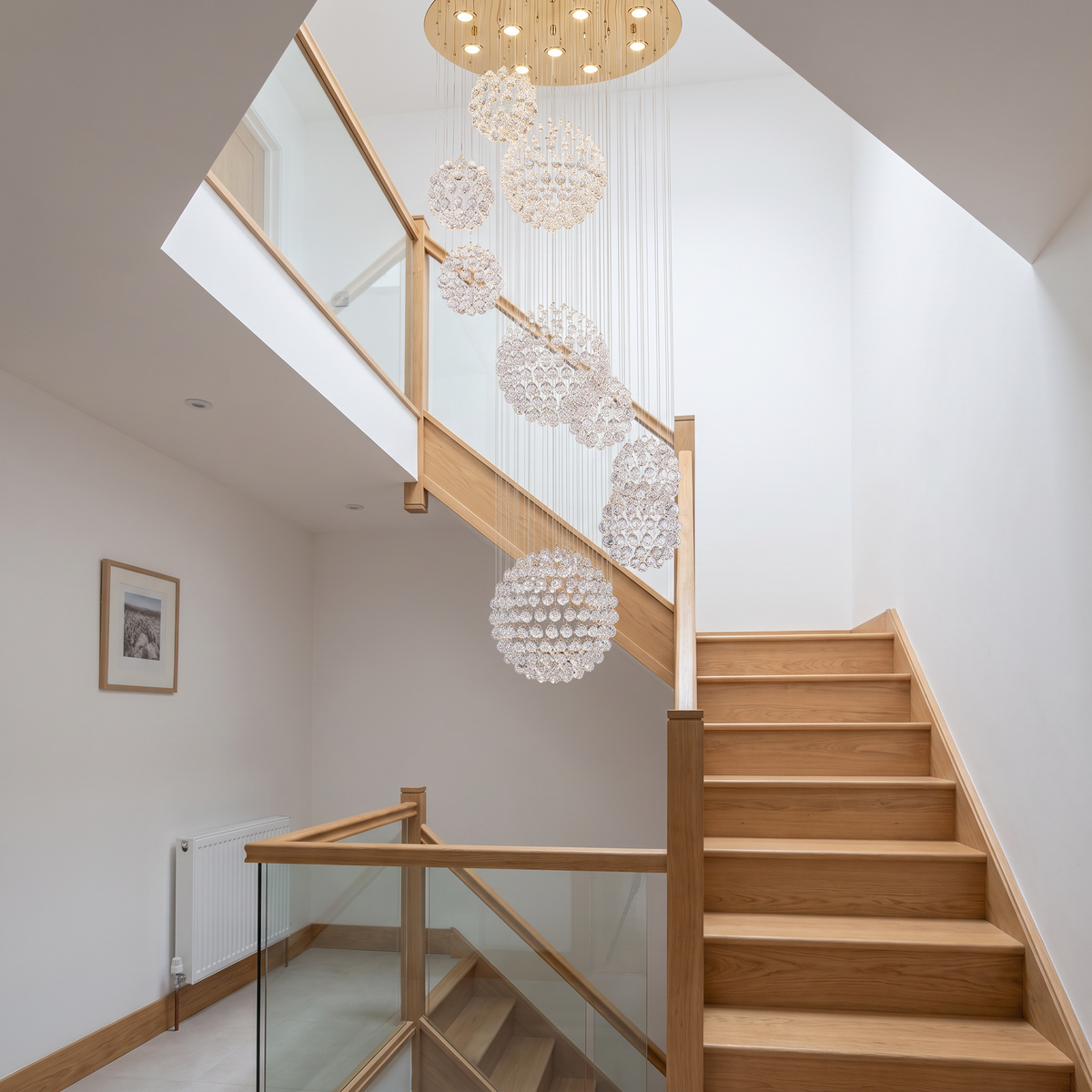Henley raindrop chandelier in a modern stairwell with glass balustrade
