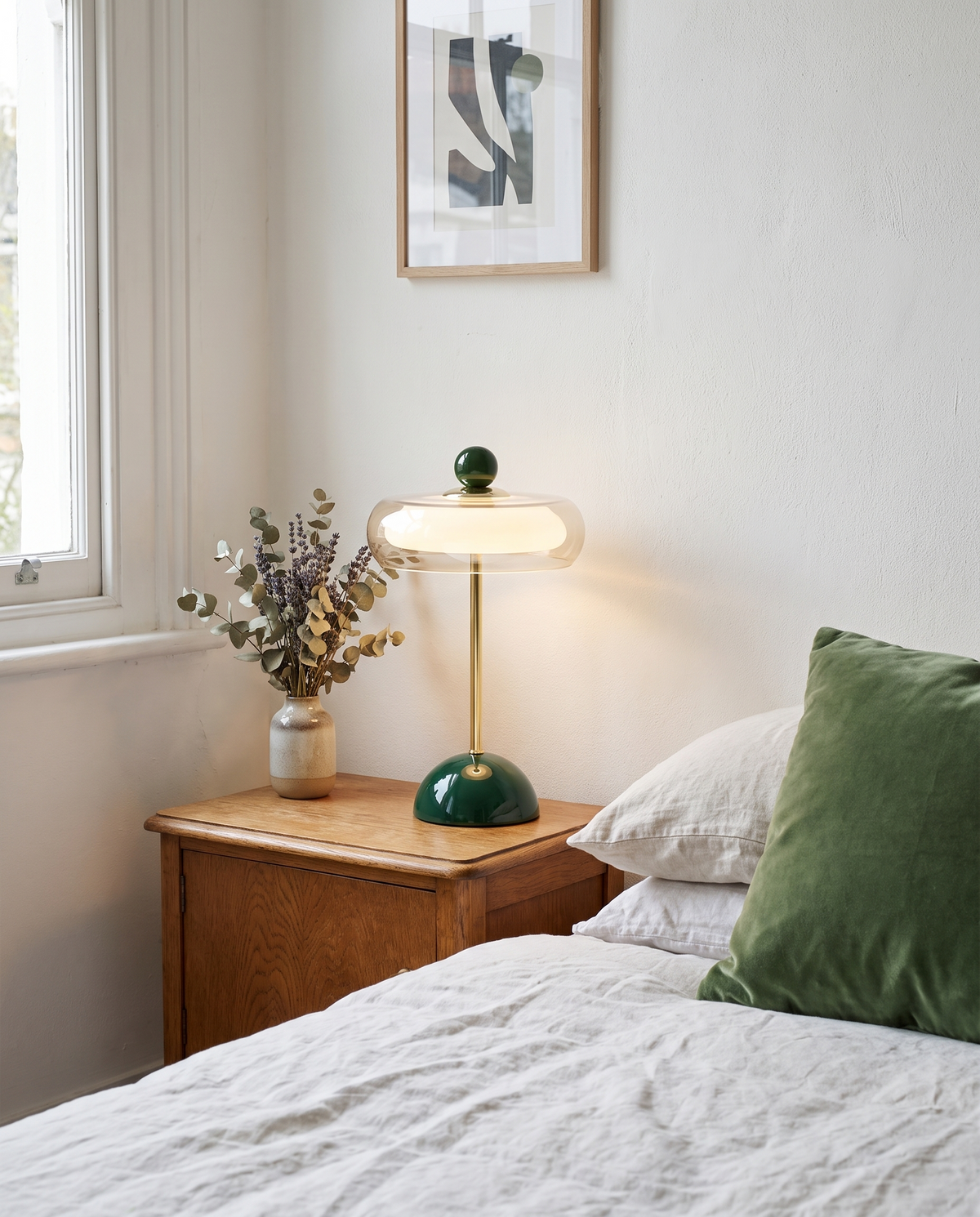 Portobello glass rechargeable table lamp, dark green, on an oak bedside table