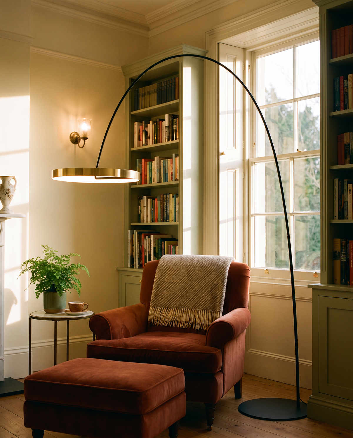 Richmond gold arc floor lamp over a rust velvet armchair in a Victorian reading corner