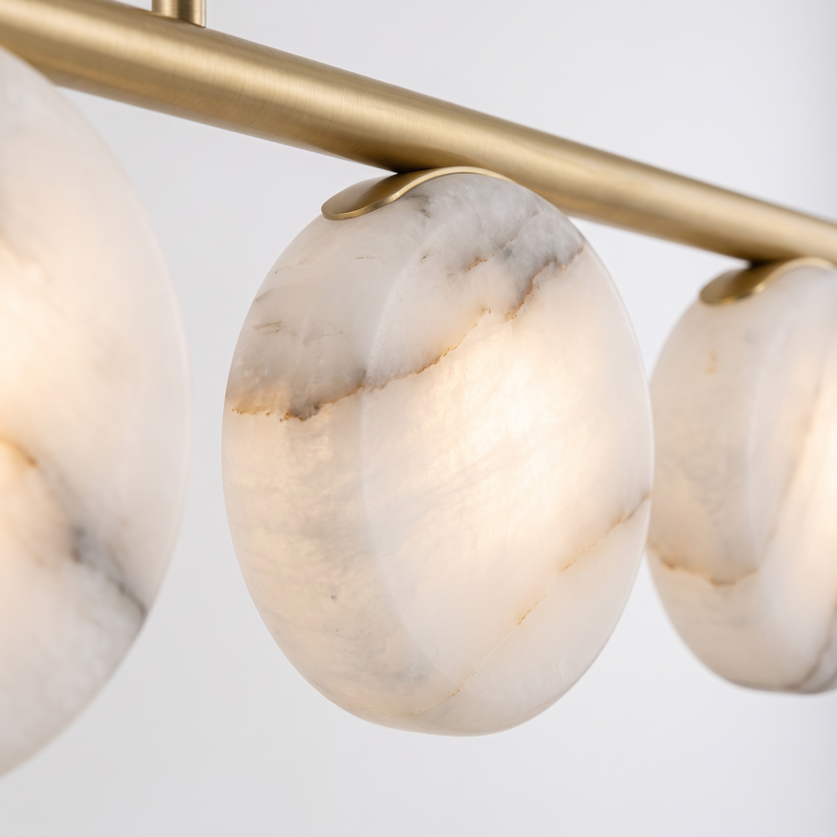 Battersea alabaster linear pendant, close-up of the veined alabaster discs and brass holders