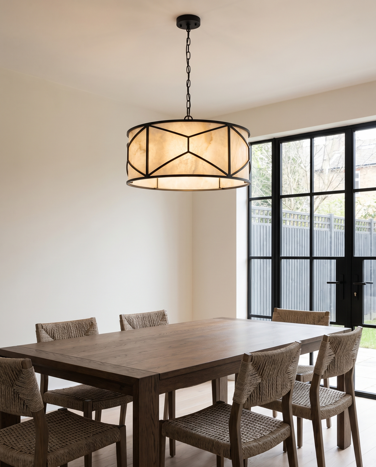Clerkenwell round alabaster chandelier in black above a modern dining table