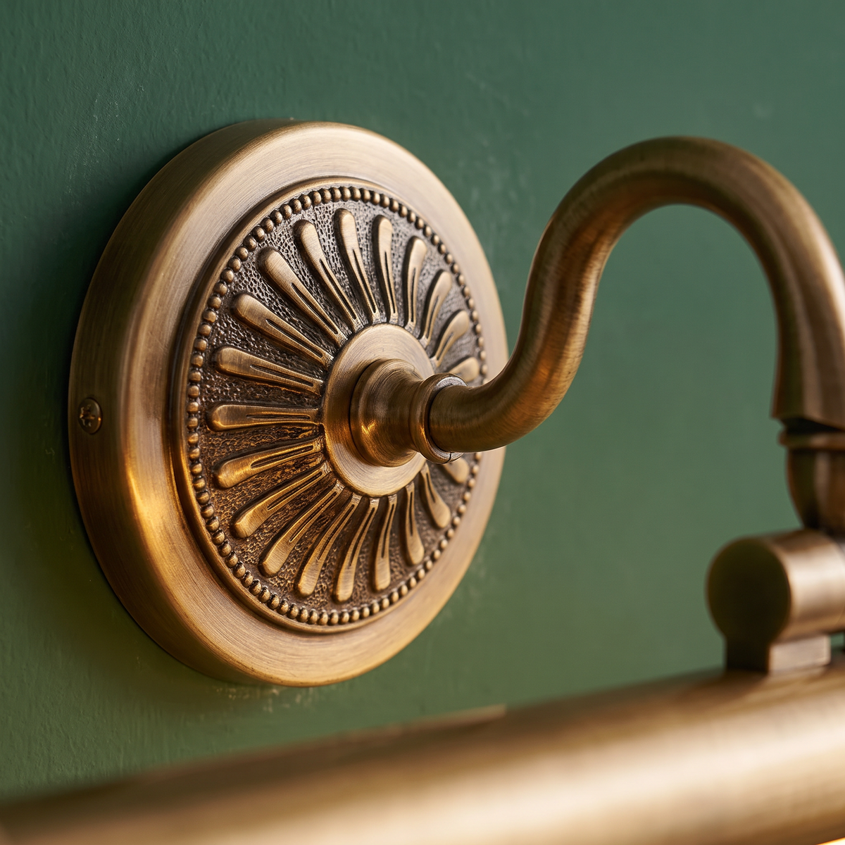 Hampstead antique brass picture light, close-up of the engraved round wall plate