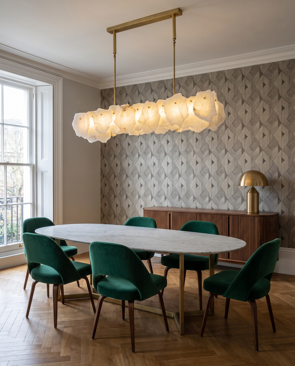 Hurlingham alabaster linear chandelier above a marble dining table with green velvet chairs