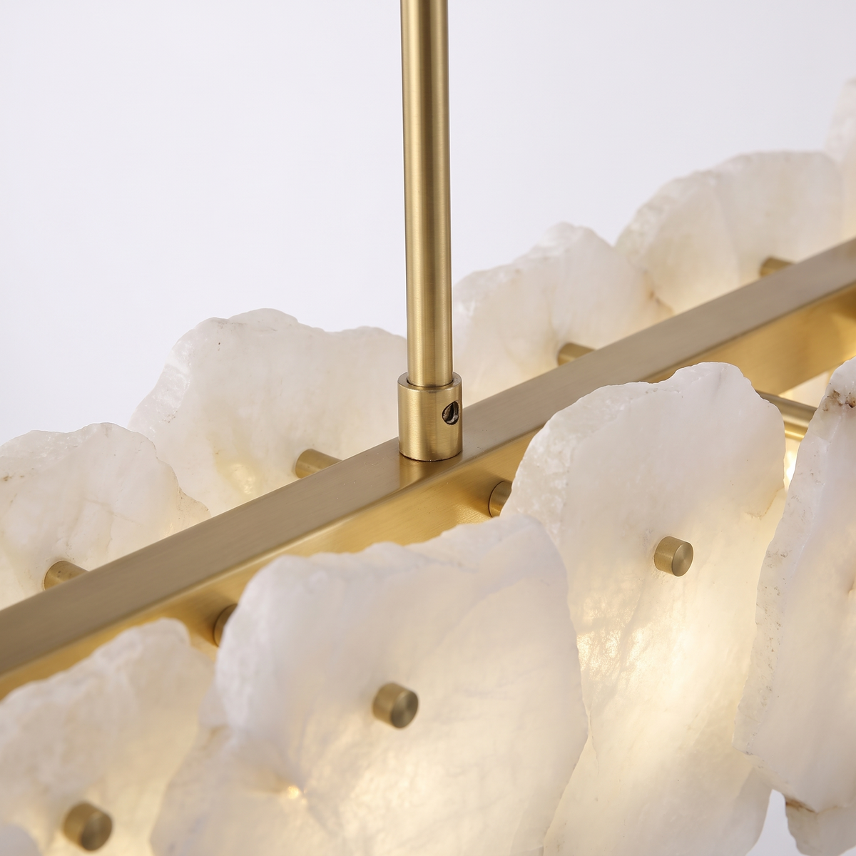Hurlingham alabaster linear chandelier, close-up of the brass rod and hand-cut alabaster slabs