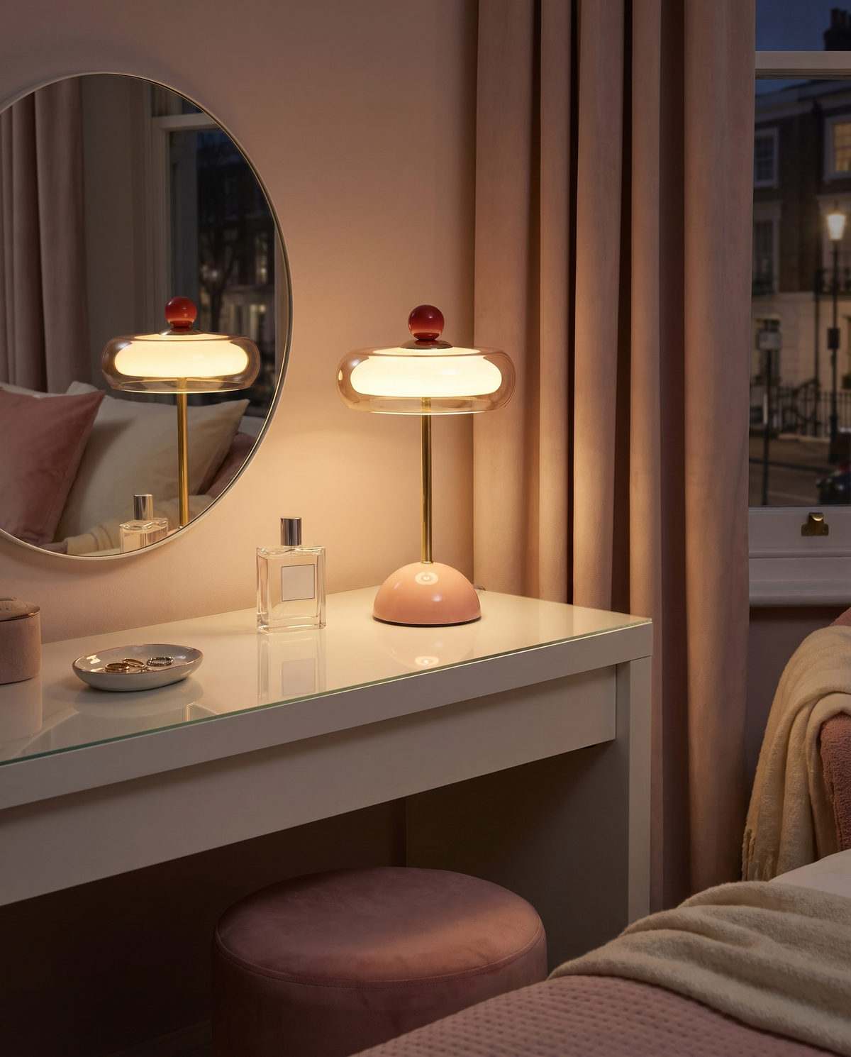 Portobello glass rechargeable table lamp, pink, lit on a dressing table