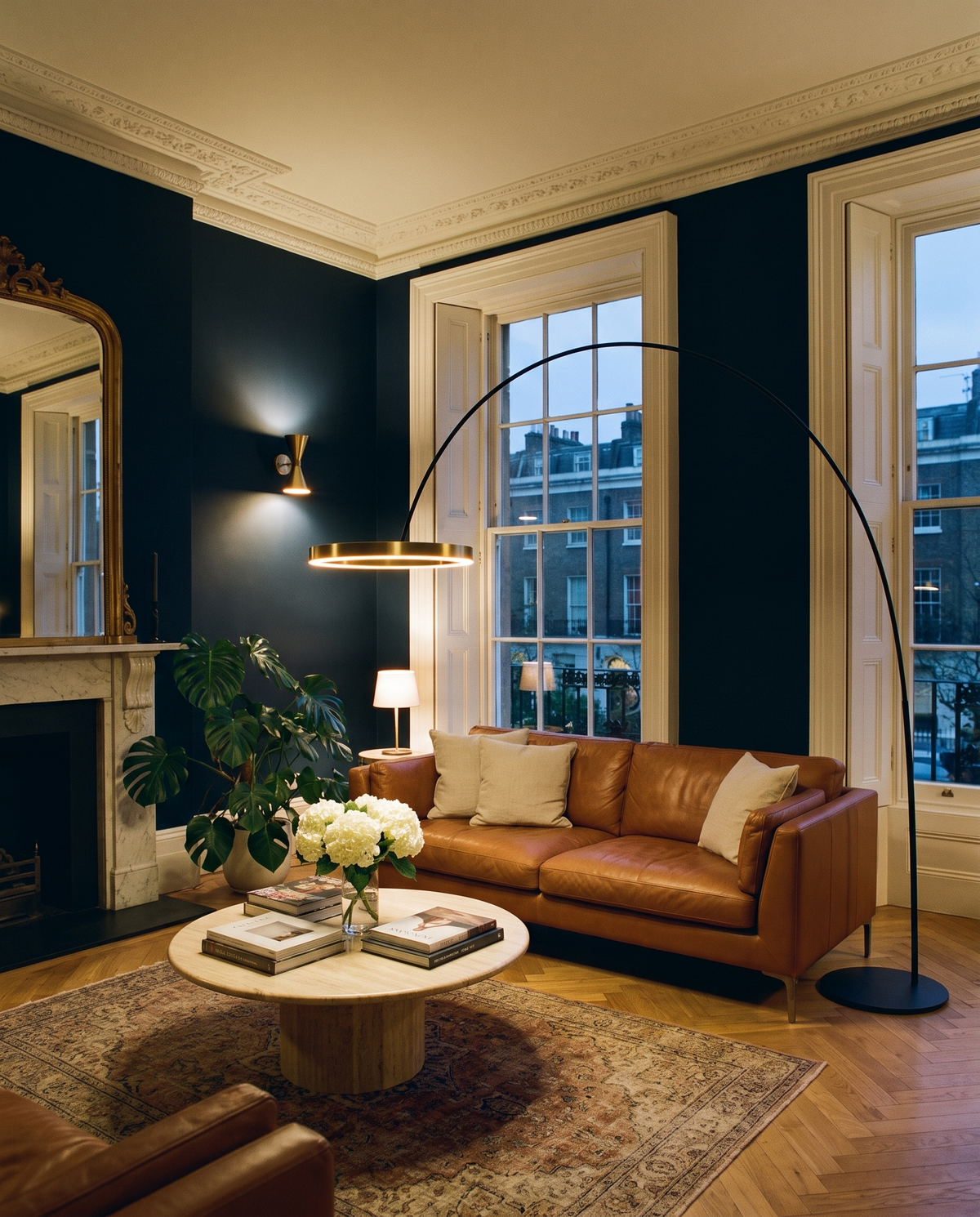 Richmond gold arc floor lamp with ring, lit above a coffee table in a navy Georgian living room
